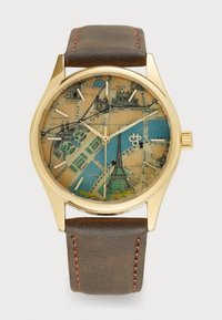 Montre-bracelet ronde avec un boîtier en ton doré, un cadran à motif carte avec des teintes bleues et beiges, et un bracelet en cuir marron avec des accents de surpiqure rouge.