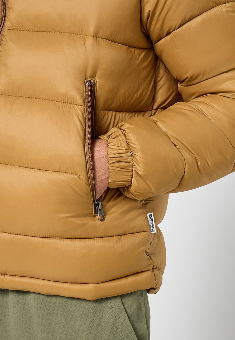 Giubbotto imbottito marrone con texture trapuntata, tasca laterale con zip e polsini elasticizzati. Il materiale sembra liscio e leggermente lucido.