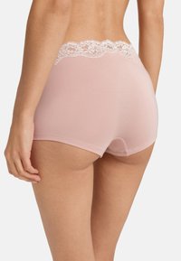 Světlé růžové bavlněné šortky s jemným krajkovým pasem. Materiál je hladký a design má středně vysoký střih bez viditelných švů.