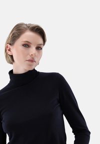 Schwarzer Rollkragenpullover aus weichem Stoff, mit langen Ärmeln, figurbetontem Schnitt und glatter Textur, vor einem schlichten weißen Hintergrund.