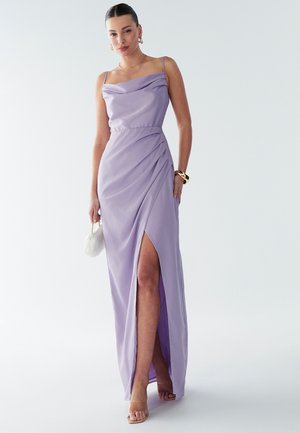Purple satin maxi dress with draped neckline, side slit, and thin straps. Features smooth texture and gathered detailing at the waist.