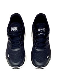 Scarpe sportive nere con tomaia in rete, suola bianca e lacci. Presentano un logo sulla linguetta e dettagli sui lati. Superficie testurizzata per una buona aderenza.