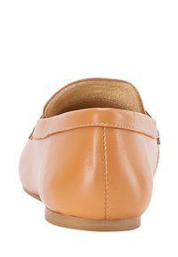 Jasnobrązowe skórzane płaskie buty o zaokrąglonym kształcie, z odsłoniętymi szwami i gładką fakturą. Minimalistyczny design bez wyraźnych akcesoriów czy ozdobnych elementów.