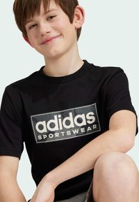 adidas Sportswear CAMO LINEAR GRAPHIC TEE - Camiseta estampada - black