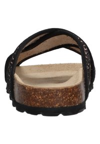 Svarta mockaskor med korkfotbed, som har två tunna remmar som korsar över fotvalvet och en texturerad gummisula.