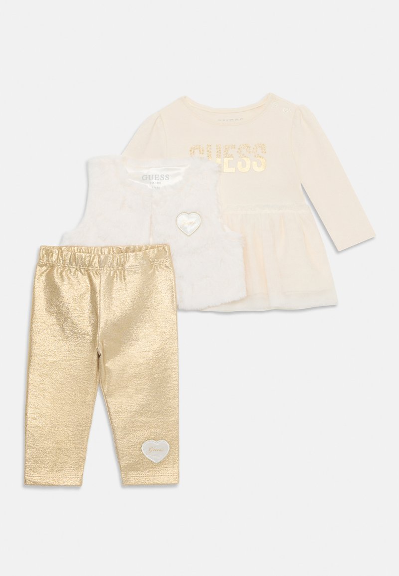 Three-piece outfit set including a cream long-sleeve top with gold lettering, a white faux fur vest with a heart detail, and gold leggings.