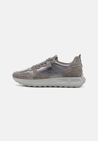 Zapatilla gris que presenta una combinación de materiales sintéticos suaves y ante texturizado, cierre de cordones y una suela de goma gruesa.