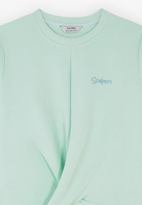 Sweatshirt verde menta chiaro con colletto rotondo, caratterizzato da pieghe sottili e un logo ricamato "Scalpers" in una tonalità corrispondente.
