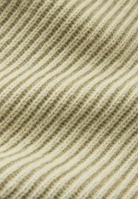 Gebreide stof in lichtbeige met een gestructureerd, golvend ribbelpatroon. Zacht, wolachtig materiaal met zichtbare draadjes en subtiele kleurnuances.