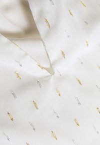 Tessuto bianco con una texture sottile, adornato da piccoli motivi ricamati in oro e argento, disposti in vari modelli e orientamenti.