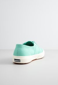 Miętowe płócienne trampki z białą gumową podeszwą. Posiadają teksturowaną górę, zaokrąglony czubek oraz logo na pięcie. Klasyczny fason na sznurówki.