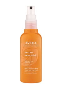 Aveda Sun Care Beschermende Haarspray in een oranje plastic sprayfles. Beschikt over een doorschijnende spraymond en witte tekst met een plantaardig ontwerp.