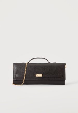 Μαύρο δερμάτινο clutch με κούμπωμα χρυσού τόνου με περιστροφή, επάνω χερούλι και χρυσή αλυσίδα λουρί σε απλό ανοιχτό φόντο.