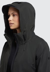Veste imperméable noire avec un col haut et une capuche réglable. Comprend une fermeture éclair à l'avant et des fermetures à pression, avec une texture mate lisse.