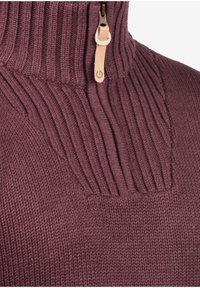 Bordeauxroter Strickpullover mit hohem, geripptem Kragen, vertikalen Rippdetails und einem Reißverschluss mit Lederakzent.