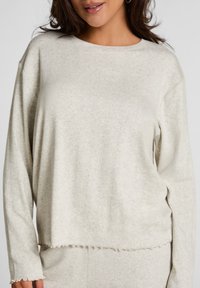 Lichtgrijze, langekleurige pullover met een gestructureerde stof, ronde halslijn en een onafgewerkte zoom, ontworpen voor een ontspannen pasvorm.