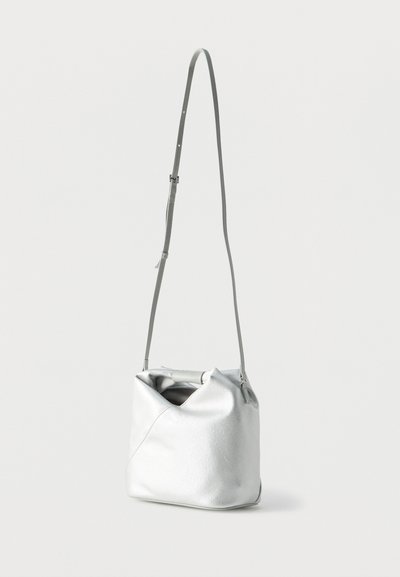 Ασημένια δερμάτινη τσάντα κάδου με μακριά ρυθμιζόμενη λουρί ώμου και κοντή λαβή που είναι κρυμμένη μέσα στο άνοιγμα.