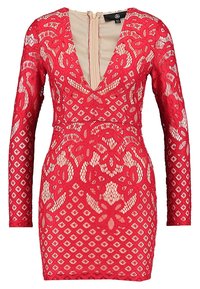 Robe en dentelle rouge à manches longues, décolleté en V profond et silhouette ajustée. Présente des motifs floraux et une fermeture éclair cachée dans le dos.