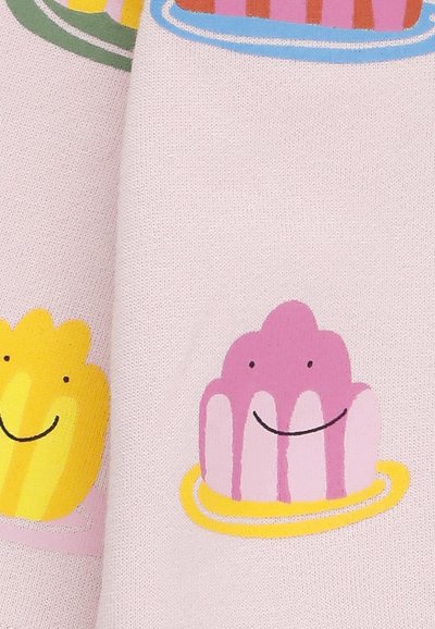 Tessuto stampato con colorati dessert di gelatina: gelatine gialle e rosa su uno sfondo rosa pastello con semplici volti sorridenti.