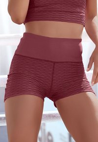 Bordeauxfarbene, hoch geschnittene Shorts mit strukturiertem Rippstoff und glatten Bereichen, entworfen für Flexibilität und Komfort, mit einer figurbetonten Silhouette.