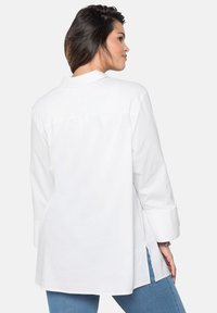 Camicetta avvolgente da donna sheego con maniche lunghe a 3/4 a punta, taglie forti 134978 Bianco Camicetta avvolgente da donna sheego con maniche lunghe a 3/4 a punta, taglie forti 134978 Bianco