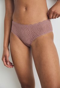 Licht mauve hipsterondergoed heeft een gegolfde tailleband, een textured geometrisch patroon en een soepele afwerking voor comfort.