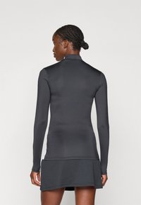 Must mustriteksti mustrept lisik, kõrge kaelusega, ribadega äärega ja sileda tekstuuriga; on voolujooneline disain ja kütte detailid külgedel.