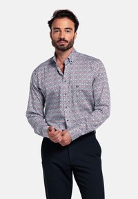 Overhemd met knoopsluiting, versierd met een geometrisch patroon van rode, blauwe en witte diamanten. Gemaakt van lichtgewicht stof met een gestructureerde kraag.