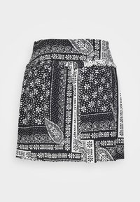 Černobílá kratší sukně se vzorem květin a paisley, s širokým pasem a lehkým materiálem.