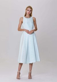 Robe sans manches bleu clair avec un tissu texturé, une taille cintrée et une jupe évasée, présentant un col en perles et des plis subtils.