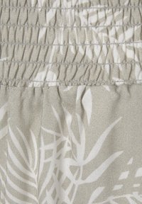 Jasnoszara tkanina z białymi wzorami liści, z marszczoną fakturą i elastycznym przeszyciem na górze. Ogólnie gładka faktura.