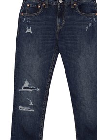 Jeans in denim blu scuro con un design usurato, caratterizzati da accenti sfilacciati e numerosi strappi nella parte anteriore. Stile classico a cinque tasche.