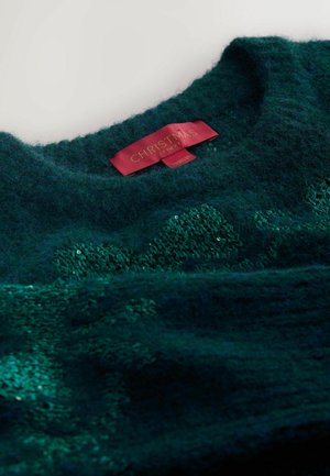 Maglione lavorato a maglia verde scuro con una finitura testurizzata. Presenta un collo rotondo e un'etichetta rossa che recita "NATALE DA NEXT."