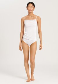 Camisola blanca con encaje en el escote, acompañada de una braguita blanca a juego. Textura suave, tirantes finos y diseño ajustado.