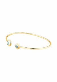 Bracciale in cuff d'oro con due pietre rotonde di un blu chiaro alle estremità. Il design è liscio, minimale e aperto per una vestibilità regolabile.