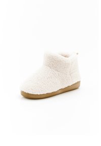 Stivaletto bianco soffice con una texture morbida, punta rotonda e suola in gomma color cuoio. Presenta un'altezza bassa alla caviglia e cuciture minime.