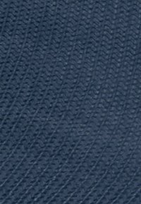 Superficie blu scuro testurizzata con un motivo ripetitivo di piccole forme ovali in rilievo disposte diagonalmente.