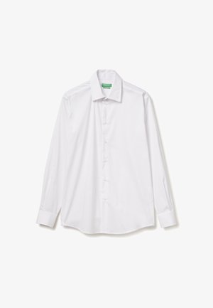 Camicia bianca a maniche lunghe realizzata in tessuto liscio, con bottoni, colletto a punta e orlo arrotondato. Nessun motivo o decorazione visibile.