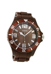 Montre en silicone marron avec un cadran circulaire, un cadran marron, des index des heures blancs, des aiguilles argentées et une lunette tournante avec des accents rouges.