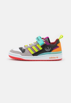 Low-top Adidas sneaker with gray suede, black and neon yellow stripes, teal strap, orange accents, red sole, and white midsole with Adidas logo.