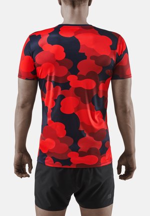 Rode en marineblauwe sport t-shirt met een wolkenachtig patroon; korte mouwen, ronde halslijn, lichtgewicht materiaal, met contrasterende shorts.