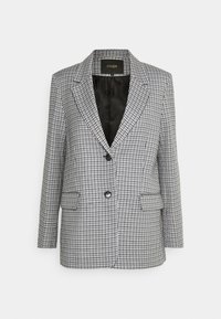 Blazer con un patrón de cuadros en blanco y negro, que presenta solapas con muesca, cierre de un solo botón y dos bolsillos frontales. Tejido texturizado.
