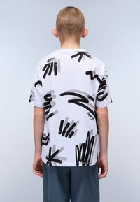 Weißes T-Shirt mit kurzen Ärmeln, das ein schwarzes und graues abstraktes Pinselstrichmuster aufweist, mit rundem Halsauschnitt und geradem Saum.