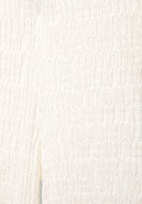 Tissu blanc avec une texture froncée et smockée créant un motif de surface froncé et extensible.