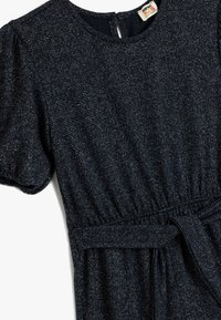 Navy blauwe jurk van textuurstof met subtiele zilveren draden. Heeft pofmouwen, een cinched taille en een strikceintuur.