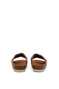 Brown leather sandals with dual crossed straps, cork footbed, and white rubber sole. View from the back, showcasing the curved design.