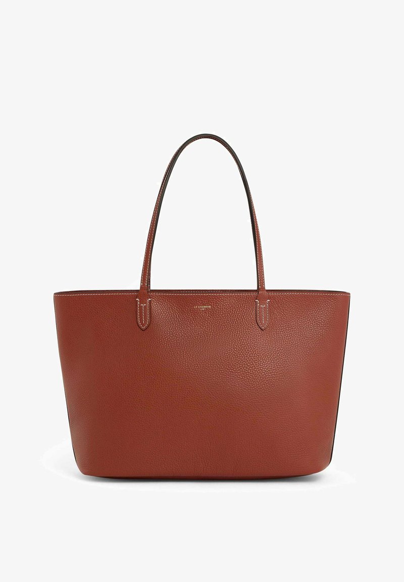 Sac fourre-tout en cuir beige avec deux longues poignées, ouverture sur le dessus, forme rectangulaire et couture blanche contrastante le long des bords.