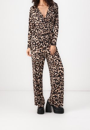 Buksedragt med leopardprint, lange ærmer, dyb V-hals og vide ben. Fremstillet af blødt stof med markante sorte og brune mønstre.