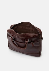 Barna bőr aktatáska cipzáras nyitással, két fogantyúval és sima felülettel. Belsejében szövet bélés és zsebek találhatók a rendezett tárolás érdekében.