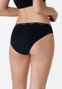 Boxer neri in cotone con un'ampia fascia elastica con testo "LOVABLE" in rosso, dalla texture liscia e dal design a vita media.